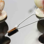 Tigers eye stone pendant on a white metal chain