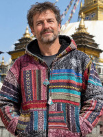 Wholesale Nepalese patchwork jacket featuring colourful handwoven cotton panels, printed motifs, a fleece-lined hood, full-zip front, and pockets.