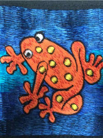 Frog wallet in bright orange with yellow spots.